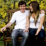 a laughing boy and girl on a bench during an on-location photoshoot